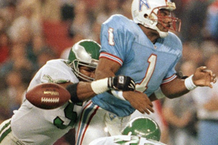 Oilers quarterback Warren Moon fumbles after being hit by Seth Joyner. (AP file photo)