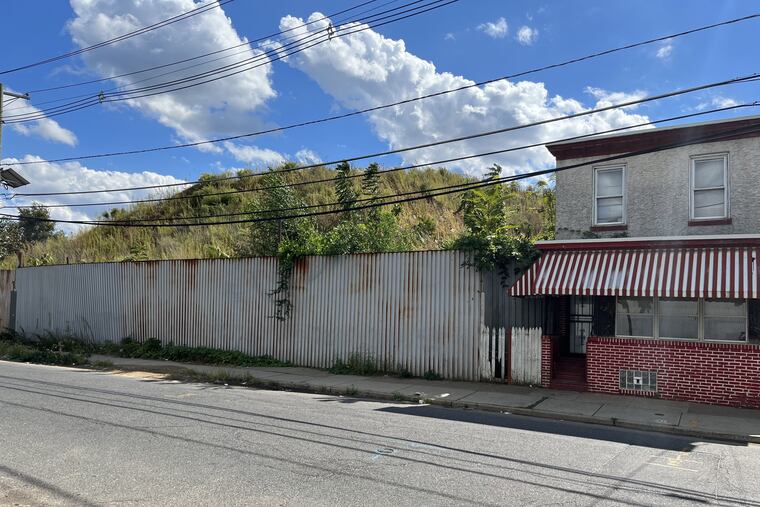 A dirt pile rises an estimated 45 feet above street level at Seventh and Chestnut Streets in Camden. Officials say they will remove the pile, and others nearby by summer 2023.
