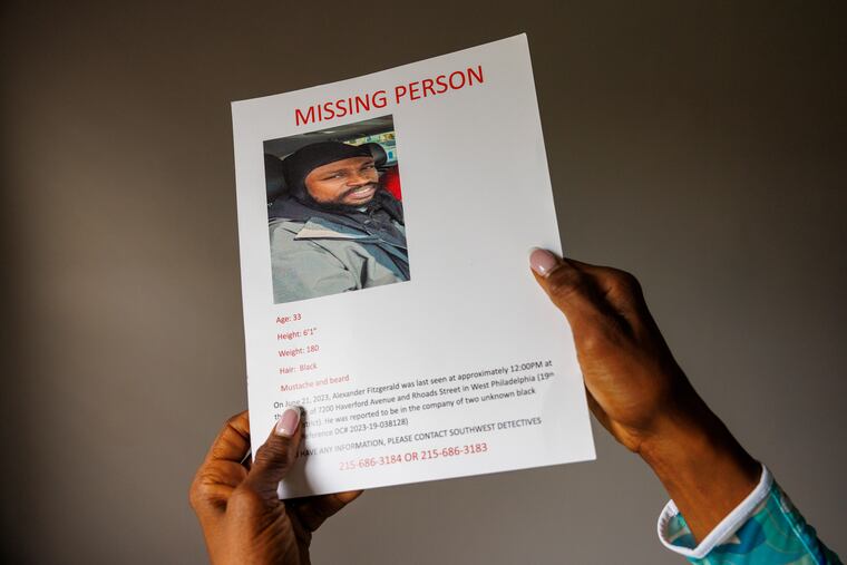 Claudia Fitzgerald holds a missing person flyer for her son, Alexander, who was last seen in June.