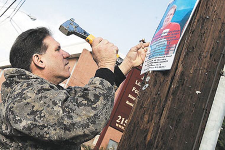 Mickey Hirsch puts up posters of his late son, Kevin, on Welsh Road in Northeast Philadelphia, warning others to get vaccinated against swine flu. (Bonnie Weller / Staff Photographer)
