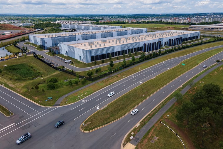 FILE - Cars drive past data centers on July 16, 2023, in Ashburn, Va. The price of constructing data centers is consuming tech giants' cash, and the clamor for computer chips is driving up consumer prices. (AP Photo/Ted Shaffrey, File)