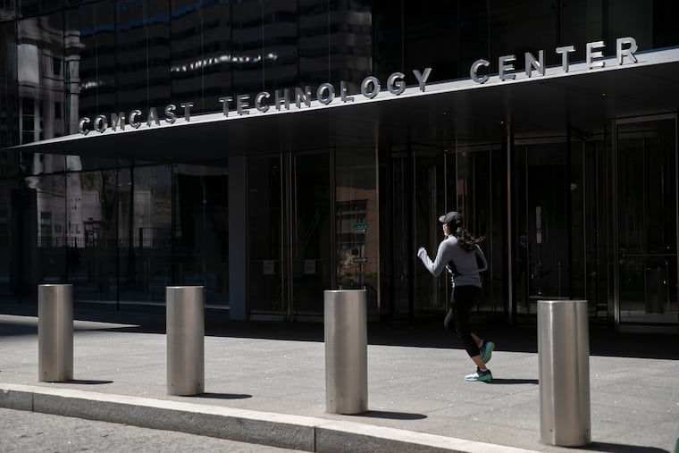 A woman jogs past the Comcast Technology Center at 18th and Arch Streets in Philadelphia.