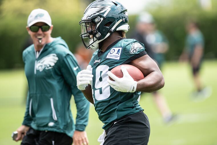 Eagles running back and punt returner Boston Scott shares a laugh with special-teams coach Dave Fipp during Monday's organized team activities.
