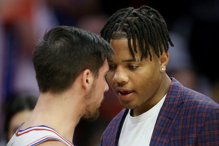 The Sixers' T.J. McConnell (12) talks with then teammate Markelle Fultz, right, during a timeout in a game against the Oklahoma City Thunder at the Wells Fargo Center on Saturday, Jan. 19, 2019.