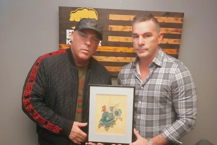 Brothers Damon, left, and David Feldman hold a painting created by their mother. The brothers use their boxing leagues to help raise awareness for mental health issues.
