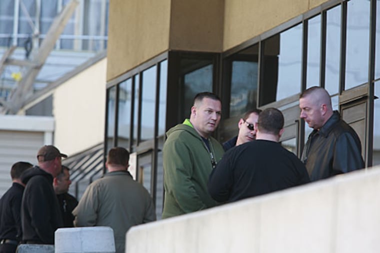 Camdem police and law enforcement officials wait in front of the emergency entrance of Cooper Universtiy Hospital for news regarding the condition of the officer who was shot early this morning.