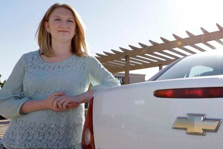 In this April 18, 2014 photo, Wendi Kunkel poses with her 2010 Chevy Cobalt in Rockwall, Texas. Kunkel was instructed by her dealer to pull everything off her keychain, which GM contends will stop the ignition switches from turning off unexpectedly. But she’s still nervous about driving her car on her 30-minute one-way commute. (AP Photo/LM Otero)