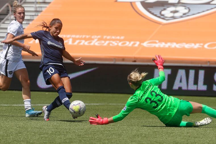 Portland Thorns goalkeeper Britt Eckerstrom (33) diving to stop the North Carolina Courage's Debinha (10) during the second half, one of Eckerstrom's eight saves in the game.