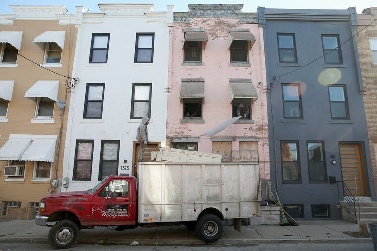 Workers clean out a house on North 27th Street in December. Prosecutors allege the house was stolen.