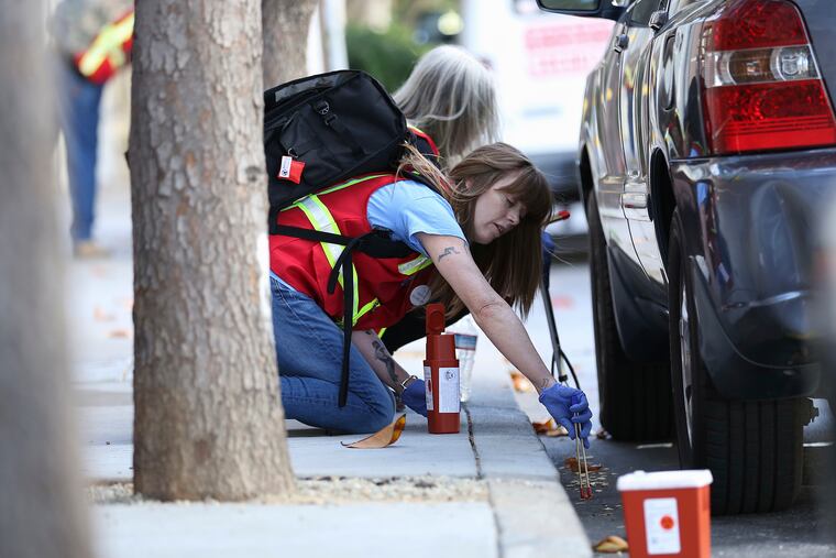Terry Morris, director of syringe access and disposal program at the 6th Street Harm Reduction Center, disposes of a discarded syringe in an alley as part of the San Francisco AIDS Foundation's Syringe Pickup Crew on Thursday, June 28, 2018. The Department of Public Health and its partners collect more than 275,000 needles every month.