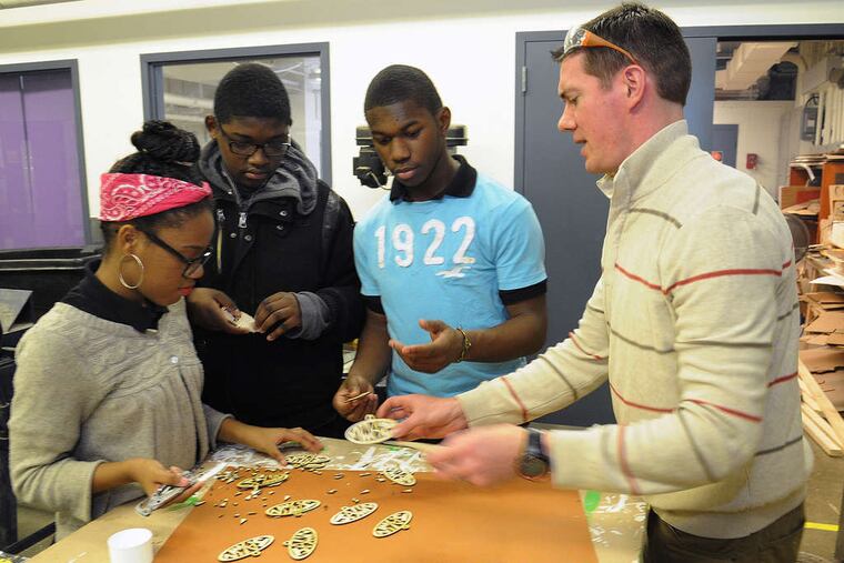 Teacher Todd Menadier and (from left) Miracle Townes, Michael Best, Christopher Mc'Near make "jawnaments" in the Workshop School program.