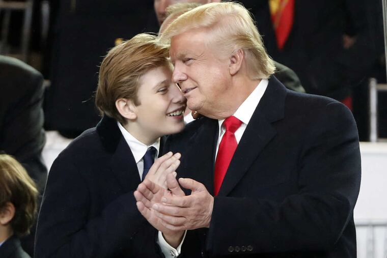 President Donald Trump, right, smiles with his son Barron as they view the 58th Presidential Inauguration parade for President Donald Trump in Washington. Friday, Jan. 20, 2017