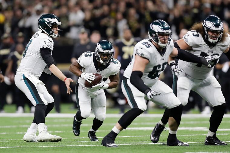 Eagles quarterback Nick Foles hands the football to running back Darren Sproles with offensive linemen Lane Johnson and Isaac Seumalo against the New Orleans Saints in a NFC Divisional playoff game on Sunday, January 13, 2019 in New Orleans. Sproles has signed for another season.