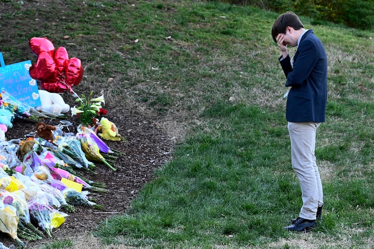 Montgomery Bell Academy student Ethan Durham grieves at a makeshift memorial by the entrance of the Covenant School, Tuesday, March 28, 2023, in Nashville, Tenn. (Mark Zaleski/The Tennessean via AP)