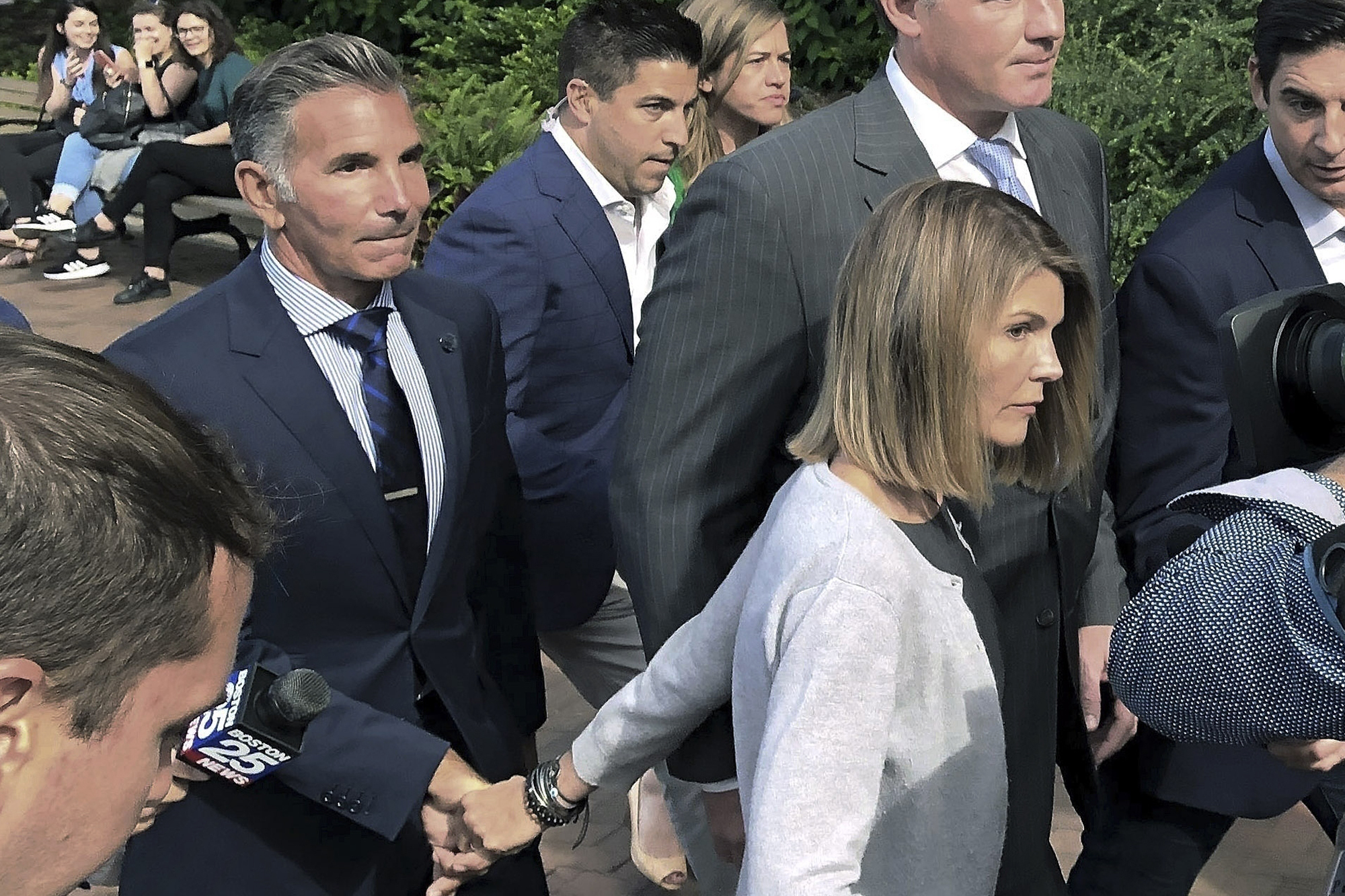 In this Aug. 27, 2019 photo, Lori Loughlin departs federal court in Boston with her husband, Mossimo Giannulli, left, after a hearing in a nationwide college admissions bribery scandal.
