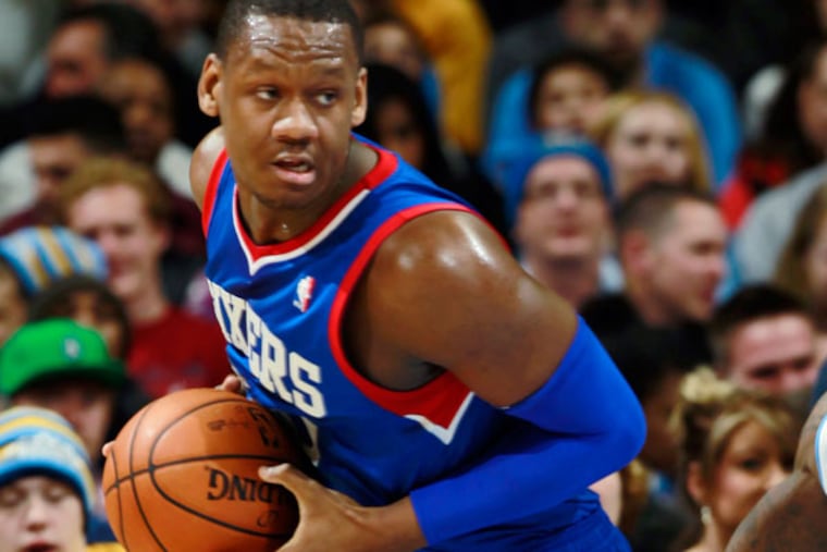 Lavoy Allen, left, picks up a loose ball as Denver Nuggets guard Nate Robinson covers in the fourth quarter of the Sixers' 114-102 victory in an NBA basketball game in Denver on Wednesday, Jan. 1, 2014. (David Zalubowski/AP)