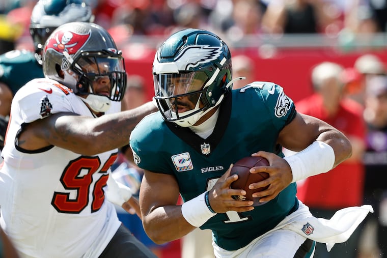 Eagles quarterback Jalen Hurts runs with the football past Tampa Bay Buccaneers defensive end William Gholston on Sunday, September 29, 2024 in Tampa.