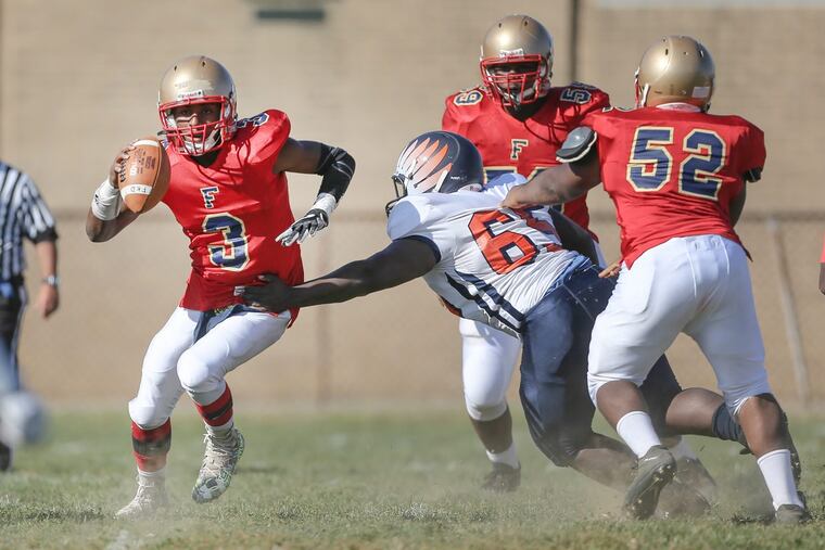 Frankford quarterback Roberto Falu tries to shake off West Philadelphia’s Tymir Singleton last season.