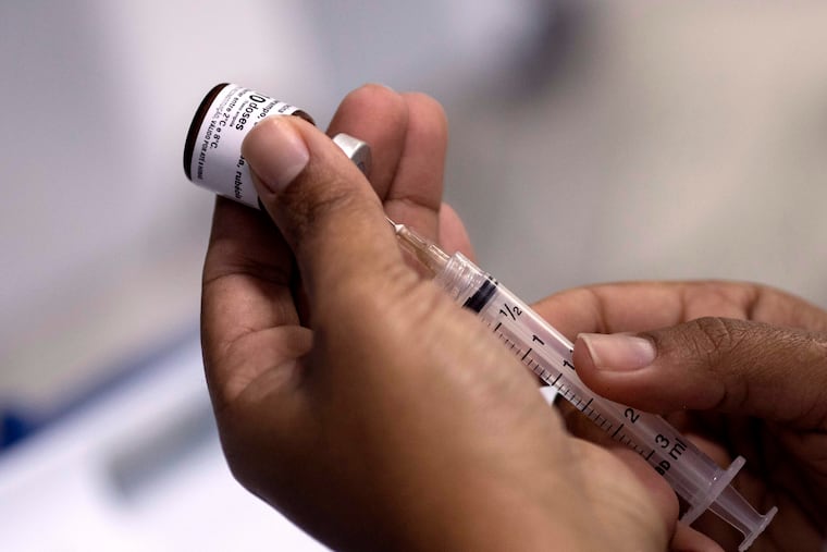 FILE – A health worker prepares a syringe with the measles vaccine in Rio de Janeiro, Brazil in August 2018.