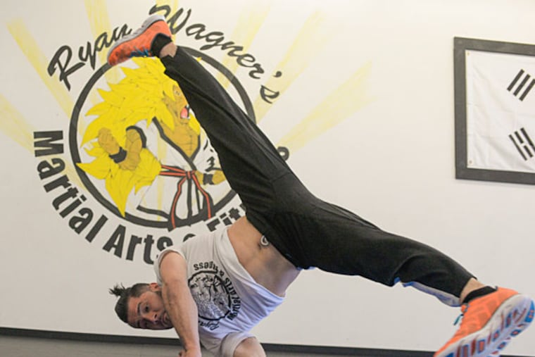 Martial arts instructor Ryan Wagner practices his break dancing moves in his studio in Bensalem in preparation for the Red Bull BC One and the North American Final break-dancing competitions in Orlando. ( BEN MIKESELL / Staff Photographer )
