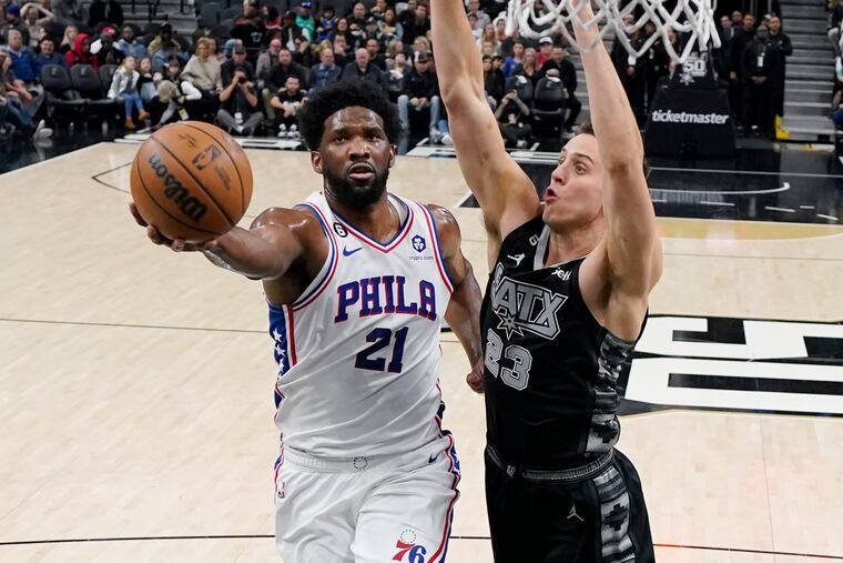 Sixers center Joel Embiid (21) drives to the basket against San Antonio Spurs forward Zach Collins in the first half.