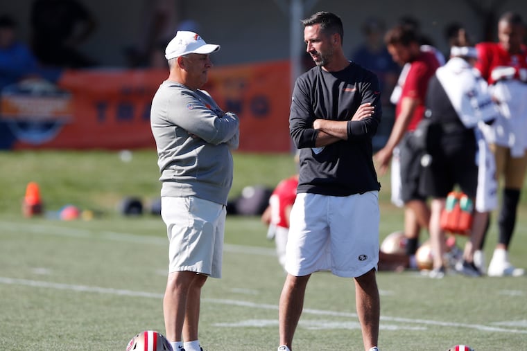 Vic Fangio (left) chats with San Francisco 49ers coach Kyle Shanahan during training camp in Denver in 2019.