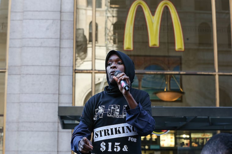 Shymara Jones, a Popeyes employee, leads the rally. She has been pressing the wage case for two years and says she has seen the benefits.