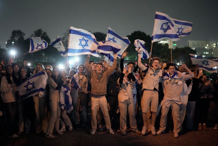 A group of Israelis celebrate as a helicopter carrying hostages released from the Gaza Strip lands at the helipad of the Schneider Children's Medical Center in Petah Tikva, Israel, on Sunday.