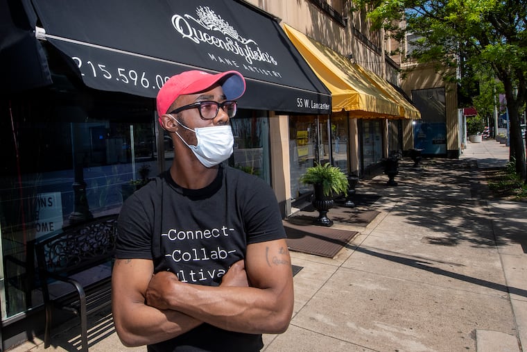 Barber Suleiman Hassan is photographed outside Queen Stylista Mane Artistry in Ardmore, Pa. Friday, May 15, 2020. Barbers have been especially hard hit because of the shutdown. So, Hassan has accepted a job driving for Amazon until things open up.