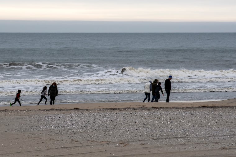 People walk along the ocean on the beach in Ventnor in March. It might look and feel a lot like this during the weekend.