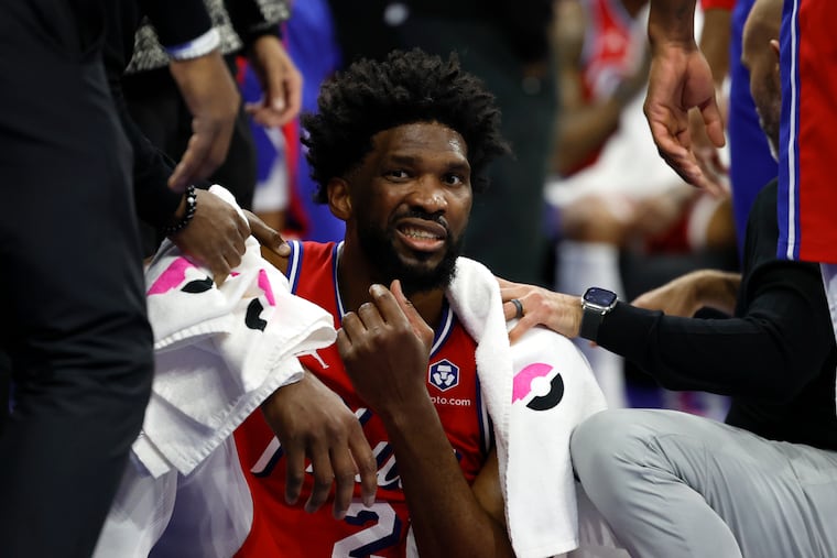 Sixers center Joel Embiid is examined after taking a forearm to his face against the Indiana Pacers on Friday.