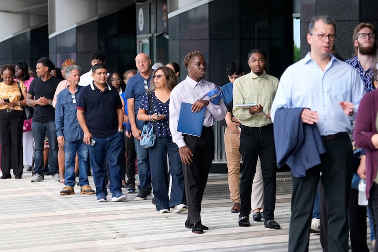 People wait in line to attend a job fair, Thursday, Aug. 29, 2024, in Sunrise, Fla. There’s a burgeoning underground market connecting job seekers to anonymous company insiders willing to help them get a foot in the door.