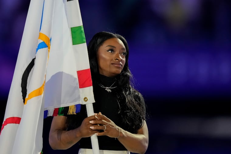 United States gymnast Simone Biles holds the Olympic flag during the 2024 Summer Olympics closing ceremony at the Stade de France on Sunday in Saint-Denis, France.