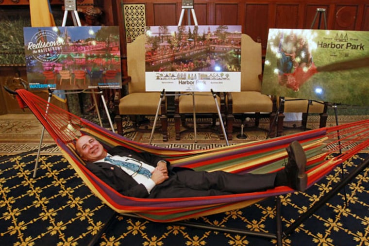 City Councilman Mark Squilla tries out one of the hammocks that will return to Spruce Street Harbor Park this summer, along with a new roller skating rink. ( Michael Bryant / Staff Photographer )