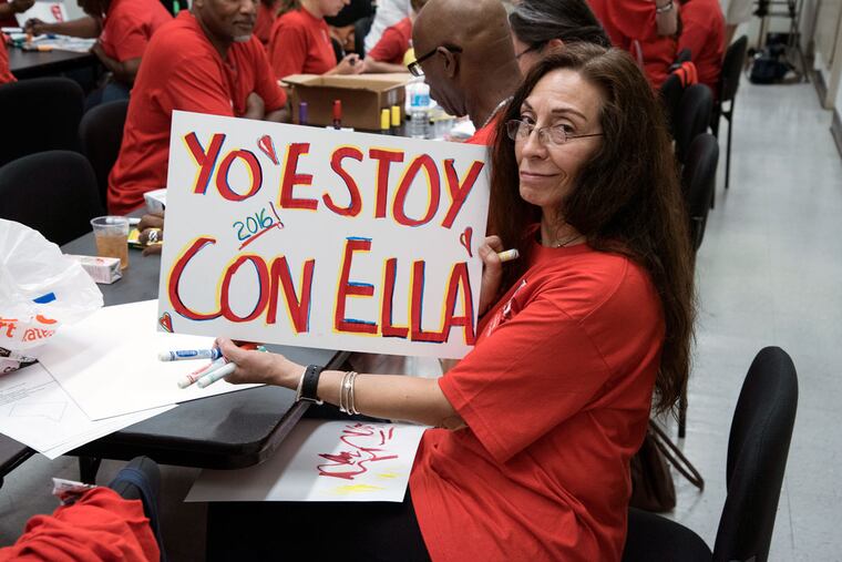 Ruth Garcia, holds up a sign written in Spanish that reads, "I am with her" at Philadelphia Federation of Teachers headquarters.