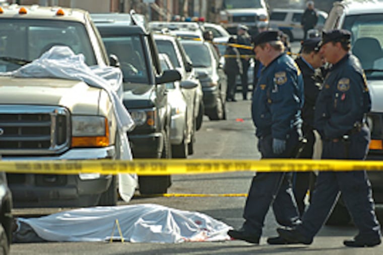Philadelphia crime scene investigators walk around the body of a man shot and killed by plainclothes police officers at 16th and Swain. (Clem Murray/Inquirer)