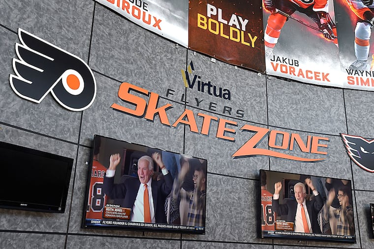 In the lobby of the Flyers Skate Zone in Voorhees, the large screen television monitors have Comcast Sports Net on with coverage of the death of Flyers owner Ed Snider, who died of bladder cancer at age 83 April 11, 2016. On the monitors, Ed Snider is shown cheering on one of his teams.