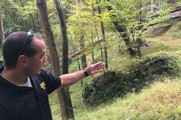 Kem Parada, of Finders Keepers, points to a rock where he and his father had dug in Elk County, believing a lost shipment of Civil War gold is buried in the area.