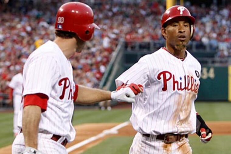 Wilson Valdez is congratulated by Chase Utley after scoring in the third inning. (Ron Cortes/Staff Photographer)
