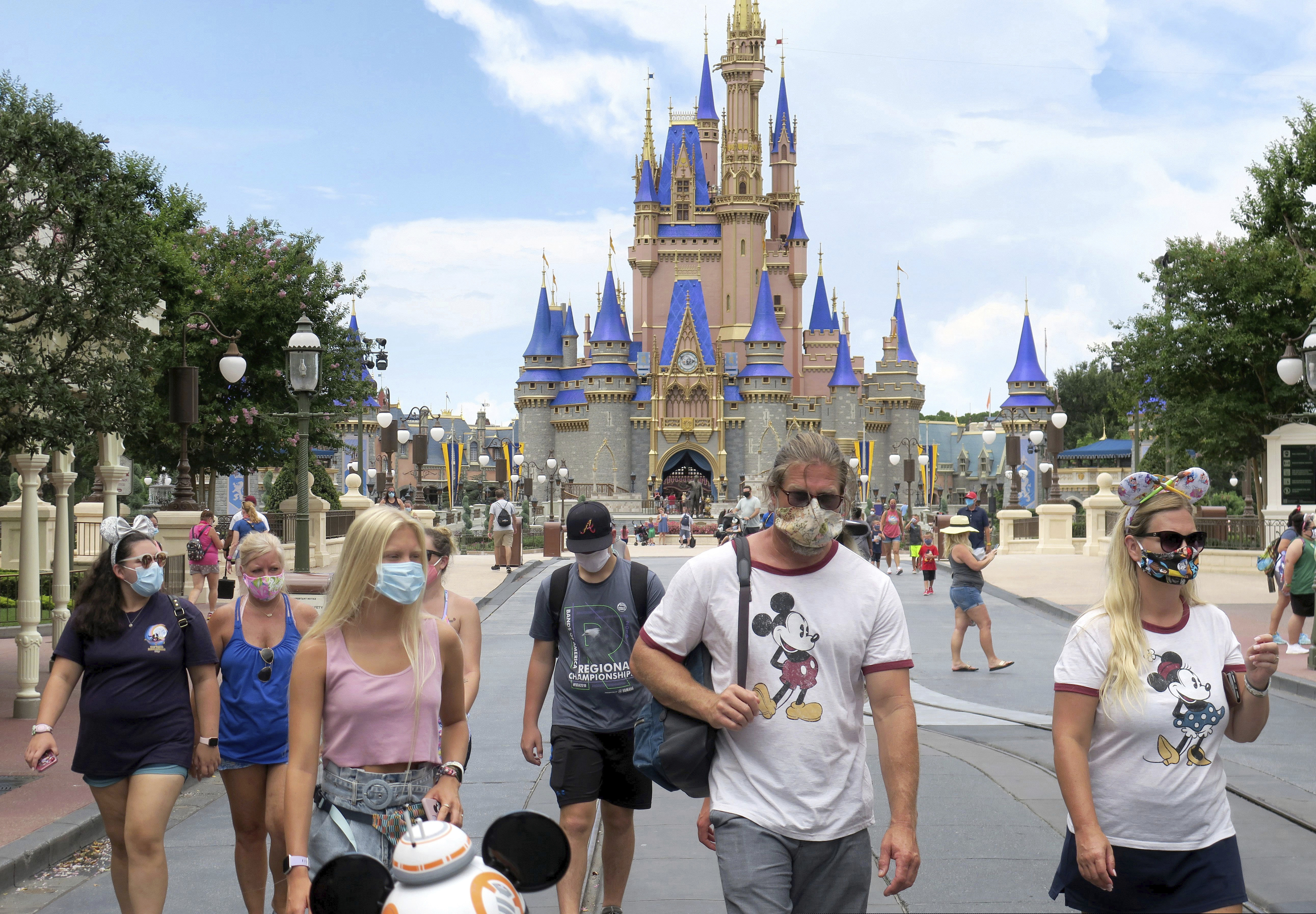 Guests wear masks as required to attend the official reopening day of the Magic Kingdom at Walt Disney World in July.