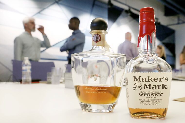 Michael Kutner, (far left) founder of Distilled Leadership, chats with students after teaching business leadership and team building with the help of bourbon and whiskey tastings, at the MakeOffices in Center City, Phila. on Aug. 24, 2018.