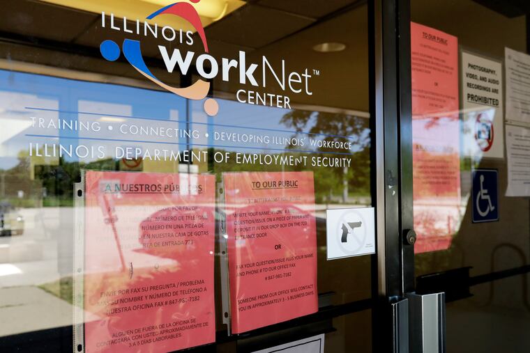 In this June 11 photo, information signs are displayed at the closed Illinois Department of Employment Security WorkNet center in Arlington Heights, Ill.
