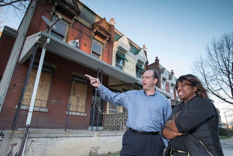 In this 2015 photo, Ken Weinstein, founder of the Jumpstart program, which gives loans and support to aspiring real estate developers, talks with Donna Tiffany Tull, one of the earliest participants in the program, on Belfield Avenue in Philadelphia's Germantown neighborhood.