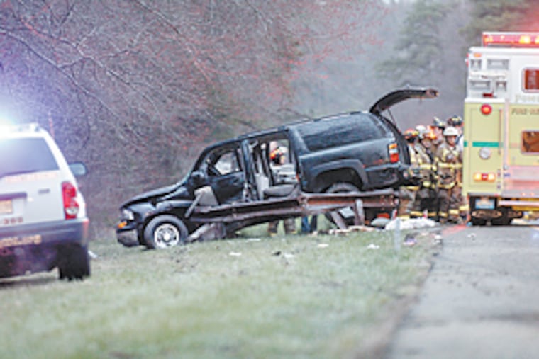 Rescue workers inspect the SUV that was carrying New Jersey Gov. Jon Corzine.