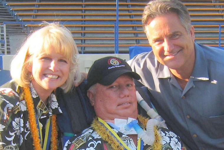 Former NFL coach Steve Mariucci (right) poses with Charlie Wedemeyer and his wife, Lucy, who assisted her husband by lip-reading and passing along instructions to his players, among other duties.