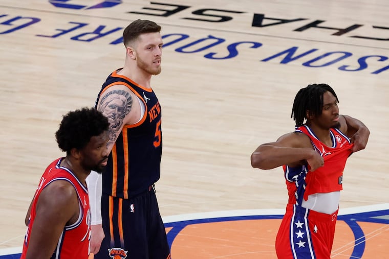 Center Joel Embiid (left) and guard Tyrese Maxey react after the Sixers lost to the New York Knicks in Game 2 of their playoff series on Monday. New York's Isaiah Hartenstein is in the middle.