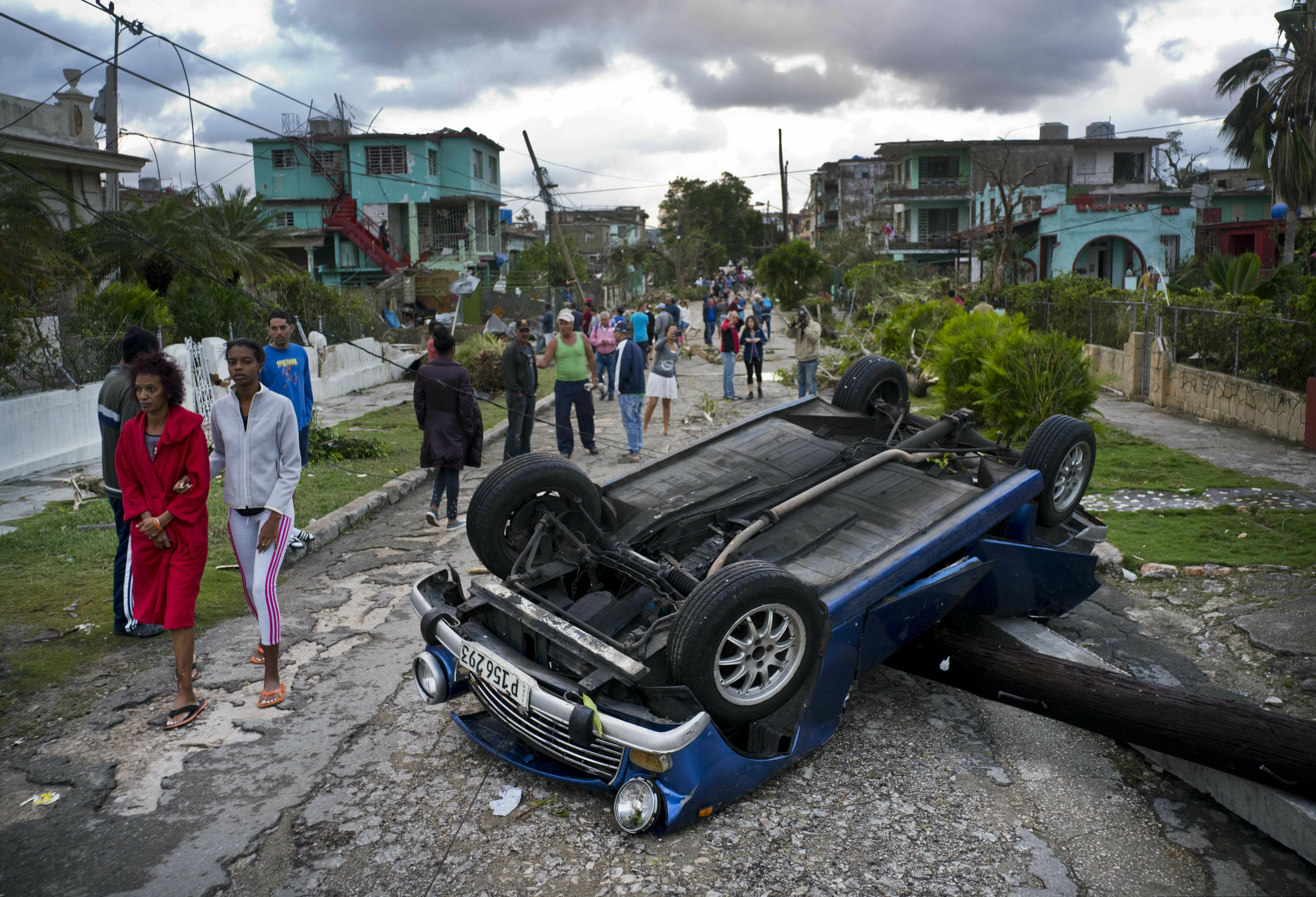 A car overturned by a tornado lays smashed on top of a street pole in Havana, Cuba, Monday, Jan. 28, 2019. A tornado and pounding rains smashed into the eastern part of Cuba's capital overnight, toppling trees, bending power poles and flinging shards of metal roofing through the air as the storm cut a path of destruction across eastern Habana. (AP Photo/Ramon Espinosa)