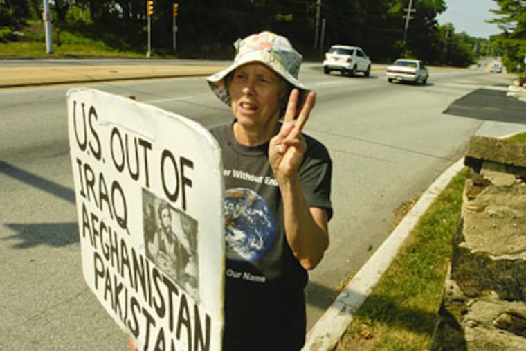 Joan Nicholson flashes a peace sign to motorist as she stands along Route 1 near Kennett Square to protest the wars in in the Middle East. (Ron Tarver / Staff Photographer