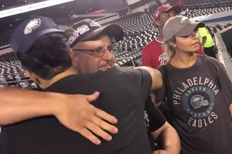 Ryan Banks hugs a fellow Eagles fans after helping to spread the remains of the man's father at Lincoln Financial Field after Thursday's win over the Atlanta Falcons.