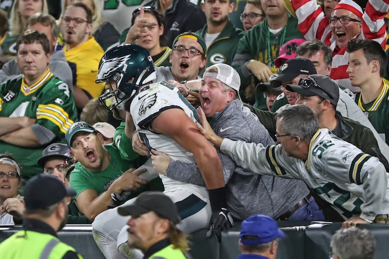 Eagles tight end Dallas Goedert is embraced by Eagles fans, as he does his version of the Lambeau Leap, after scoring the Eagles first touchdown in Thursday’s game at Lambeau Field, on Sept. 26, 2019.
